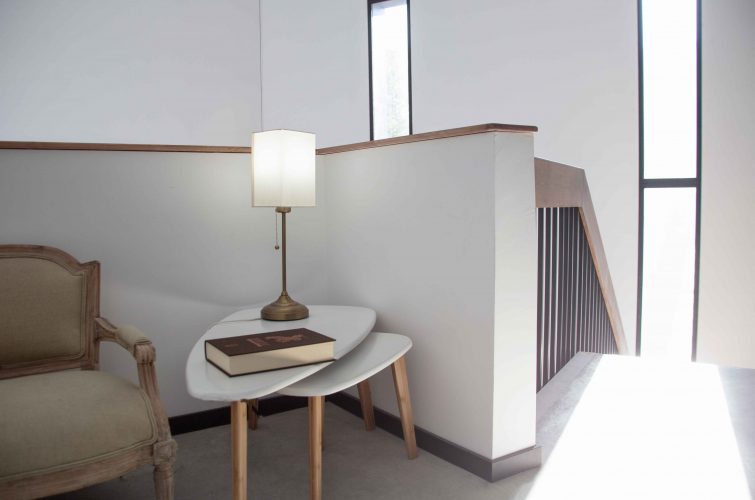 sillón con mesa, lampara y escaleras